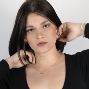 Woman wearing casual look complimented with the Two of a Kind Necklace, in sterling silver and gold plated, and the Simple Huggie Earrings